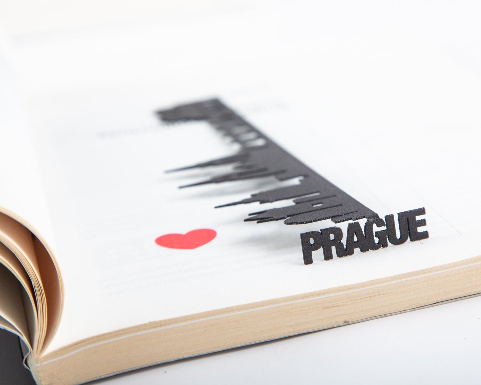 Prague Cityscape metal bookmark resting on the pages of an open book