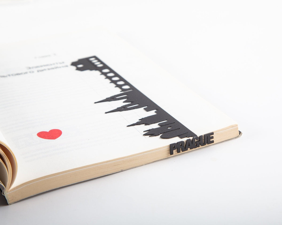 Prague Cityscape metal bookmark lying across the pages of an open book