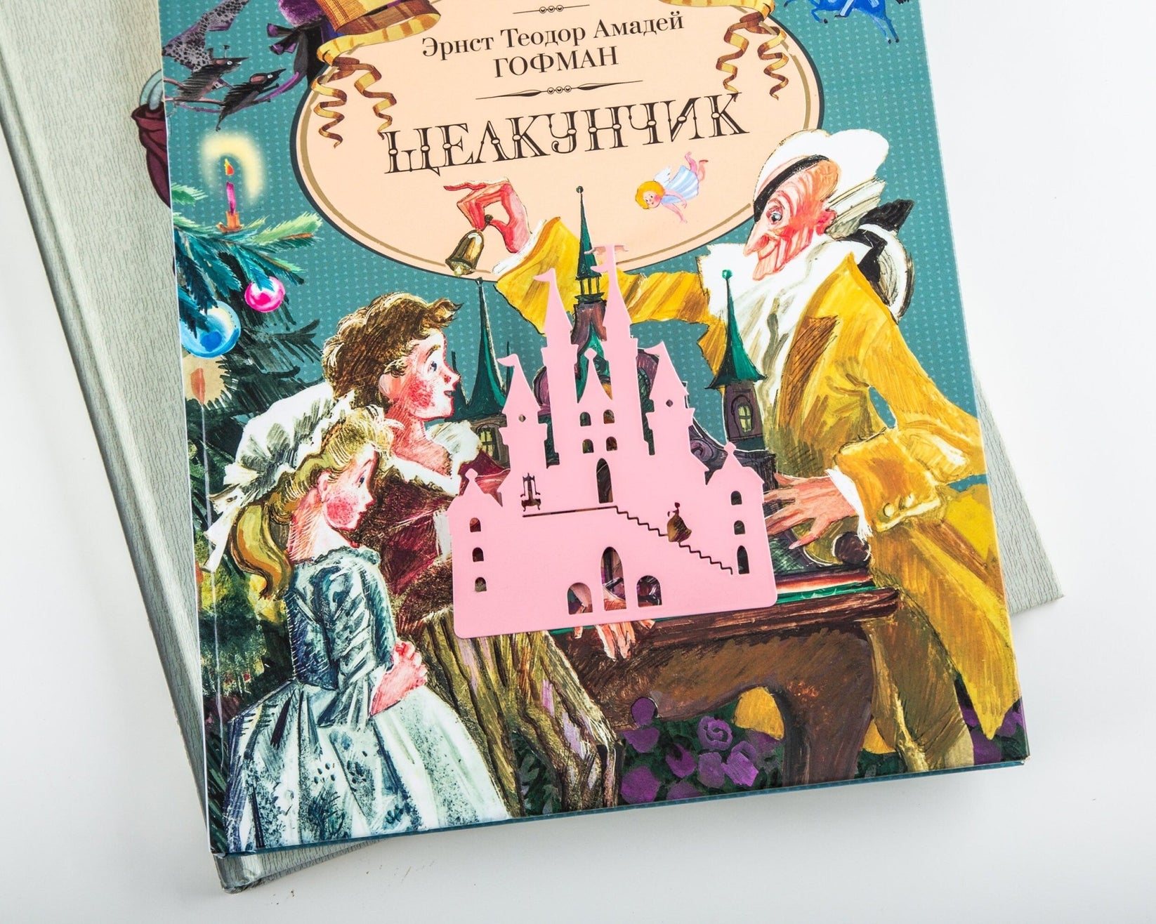 Princess Castle in Pink metal bookmark in red placed on a colour illustration