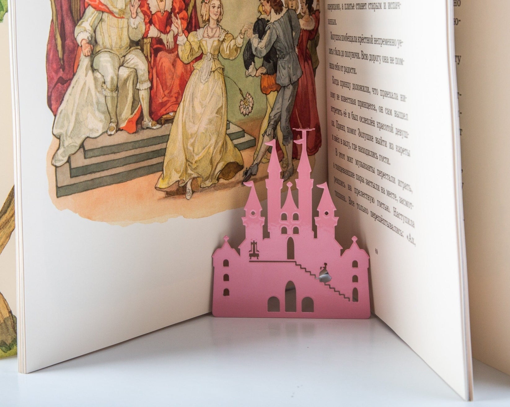 Princess Castle in Pink metal bookmark in red resting on the pages of an open book