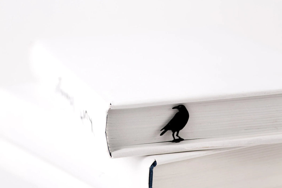 Raven metal bookmark in a closed book, only its top showing above the pages