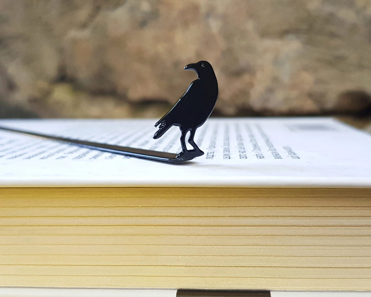Raven metal bookmark on a coloured background