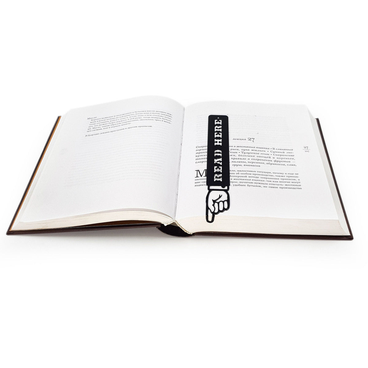 Read Here metal bookmark marking a page in an open book