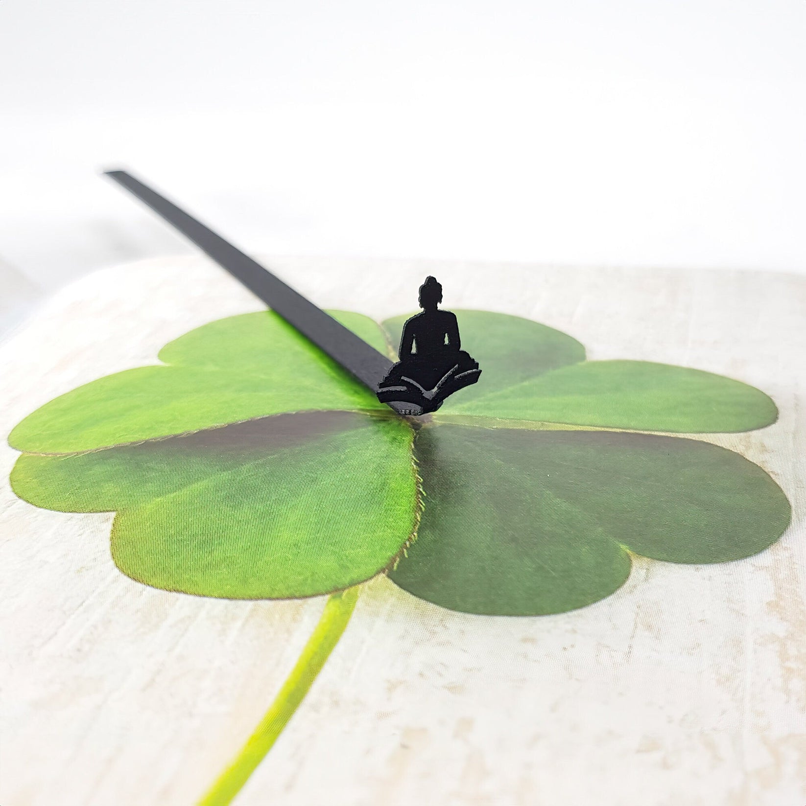 Reading Buddha metal bookmark on a coloured background