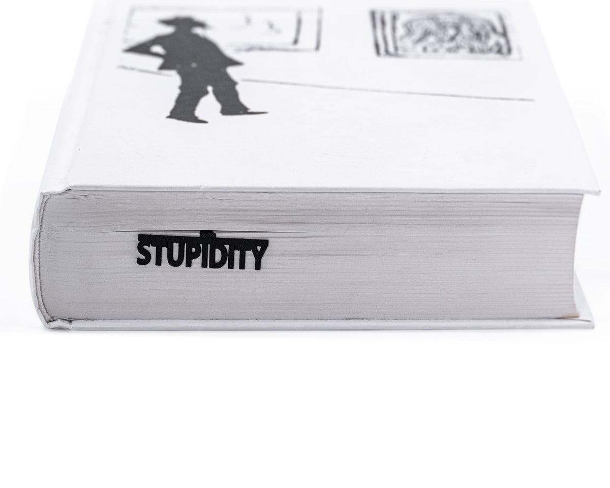 Reading Kills Stupidity metal bookmark in a closed book, only its top showing above the pages