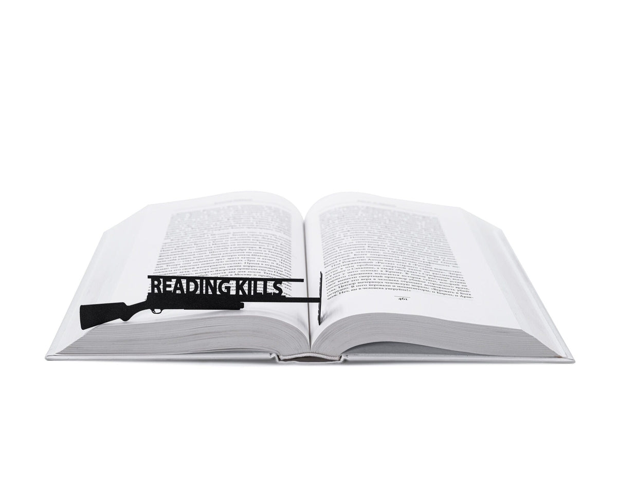 Reading Kills Stupidity metal bookmark resting on the pages of an open book
