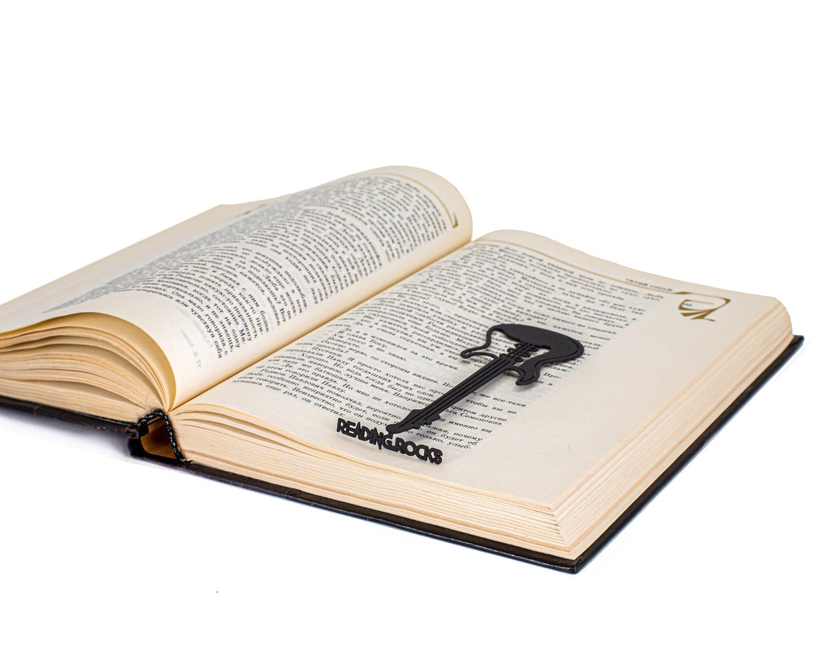 Reading Rocks metal bookmark resting on the pages of an open book