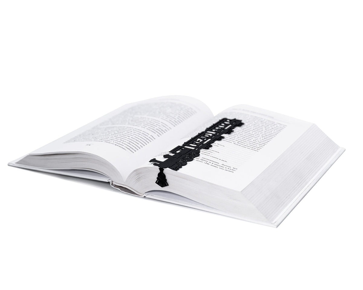 Reading Train metal bookmark marking a page in an open book