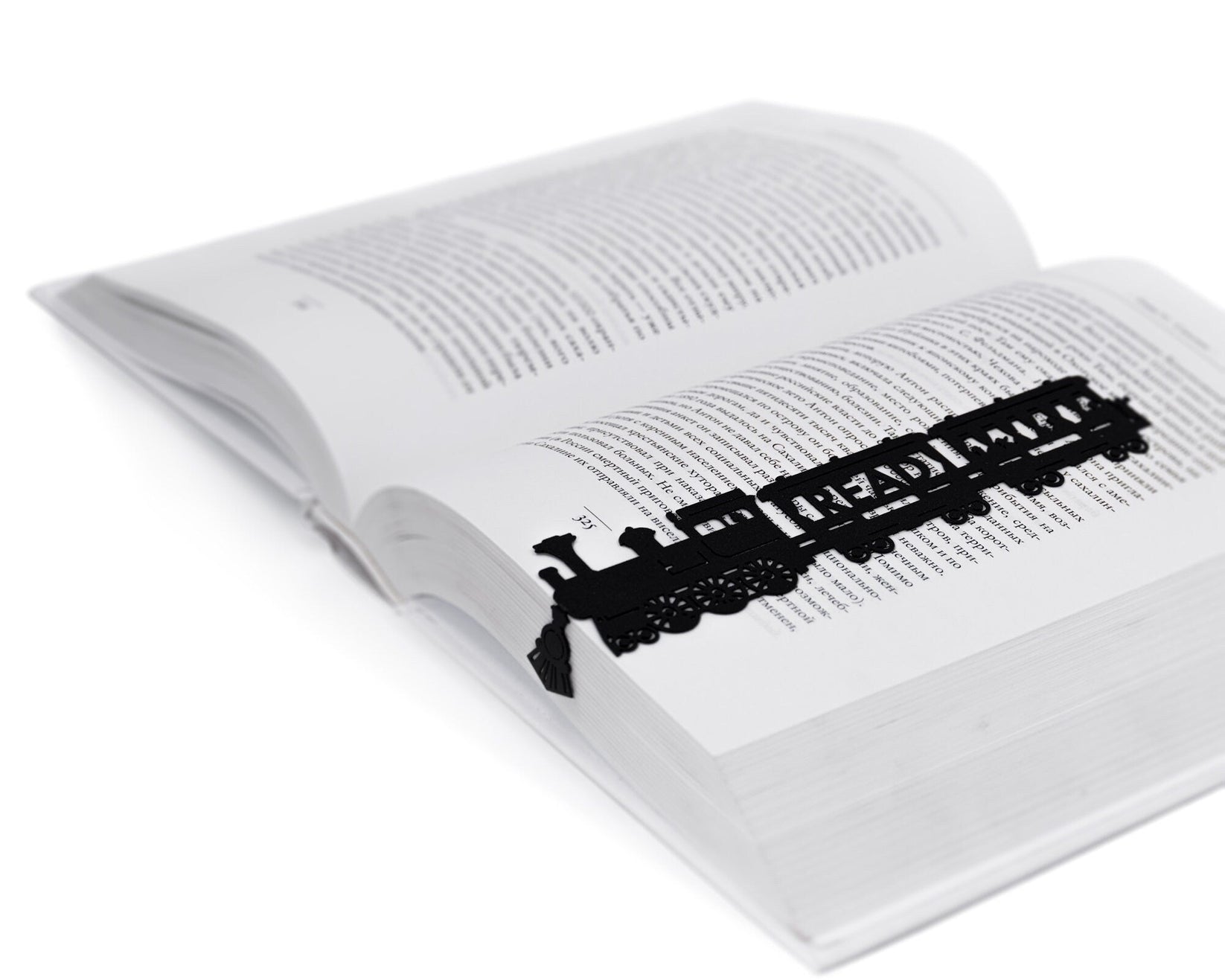 Reading Train metal bookmark lying across the pages of an open book