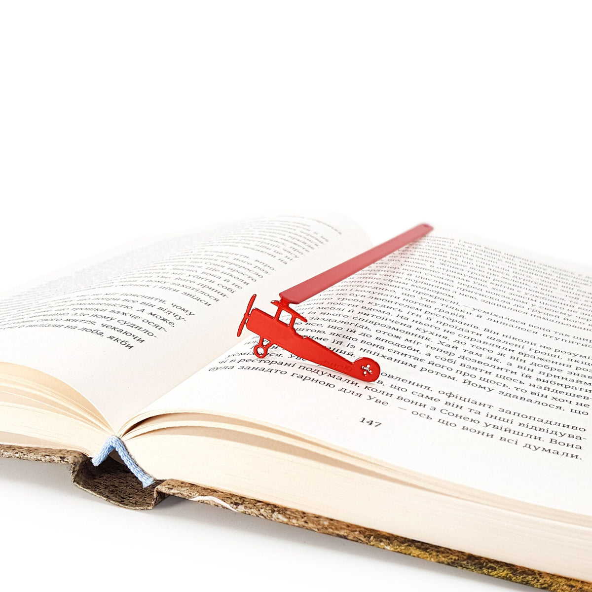 Red Biplane metal bookmark in red marking a page in an open book