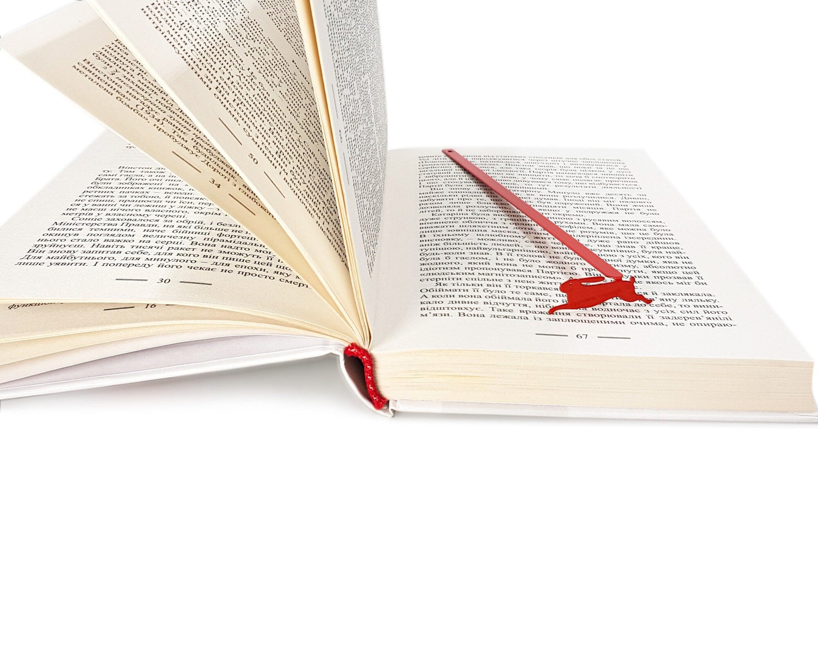 Red Rabbit metal bookmark in red marking a page in an open book