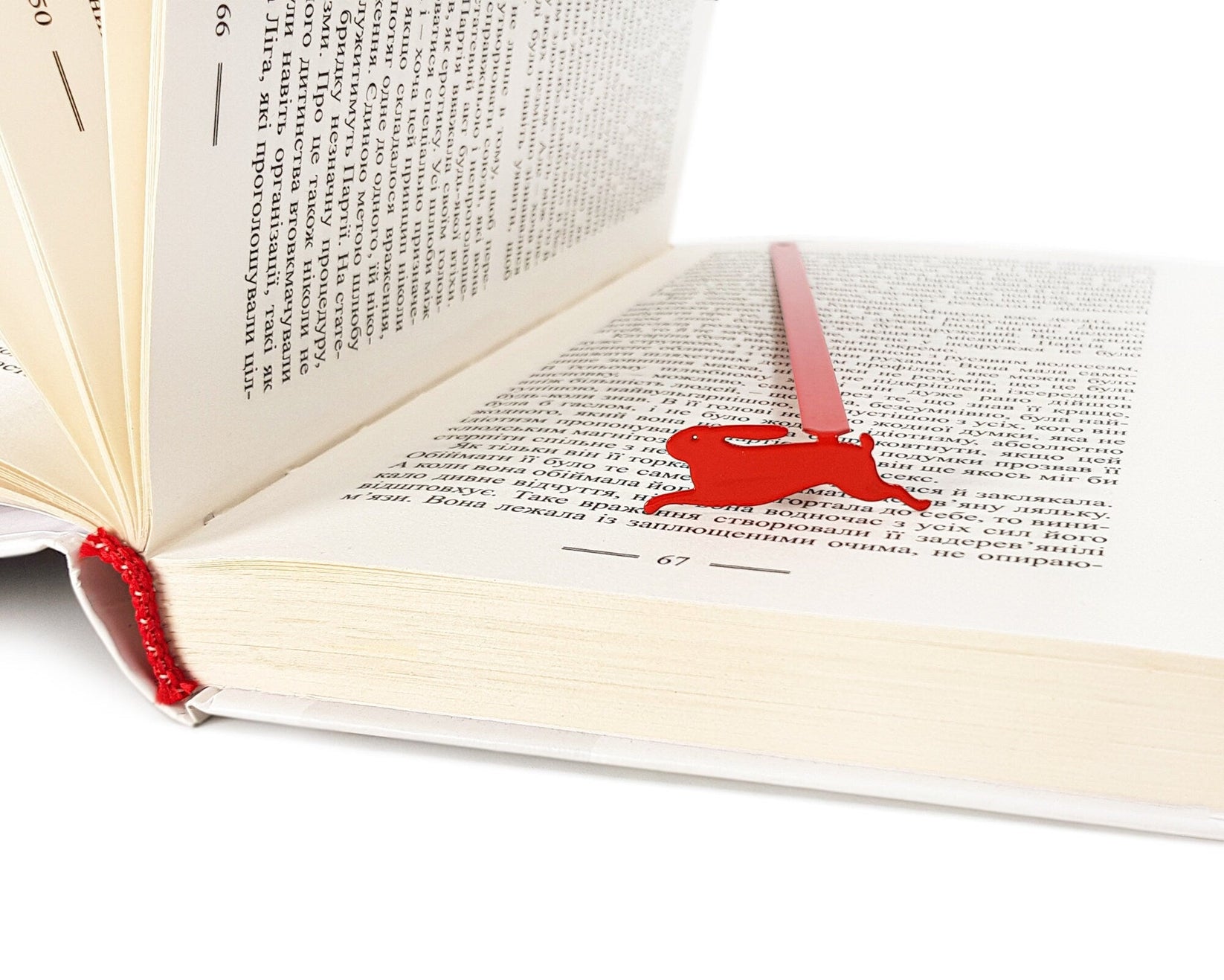 Red Rabbit metal bookmark in red in a closed book, only its top showing above the pages