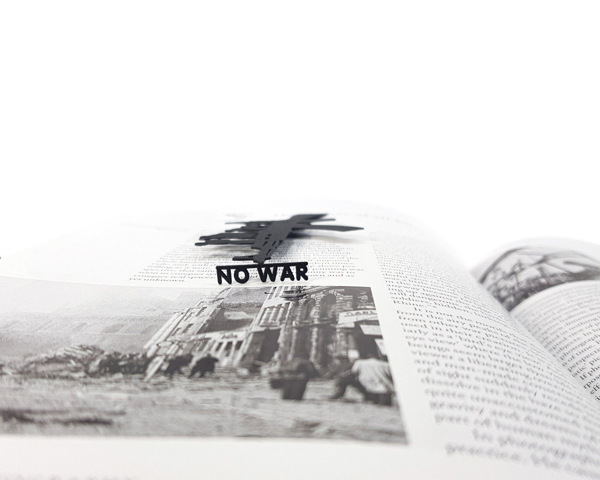 Refugees, No War in Ukraine metal bookmark placed on a colour illustration