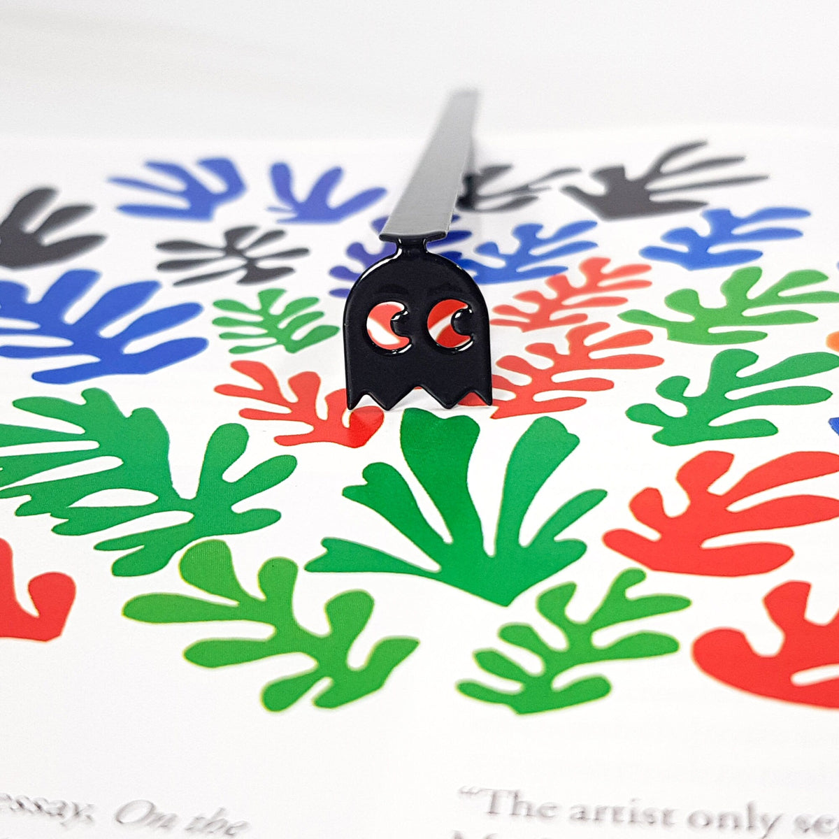 Retro Ghost metal bookmark marking a page in an illustrated book