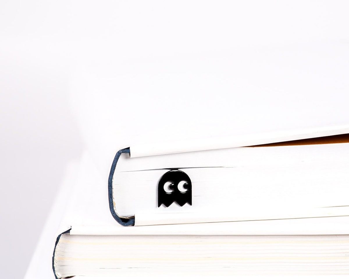 Retro Ghost metal bookmark in a closed book, only its top showing above the pages