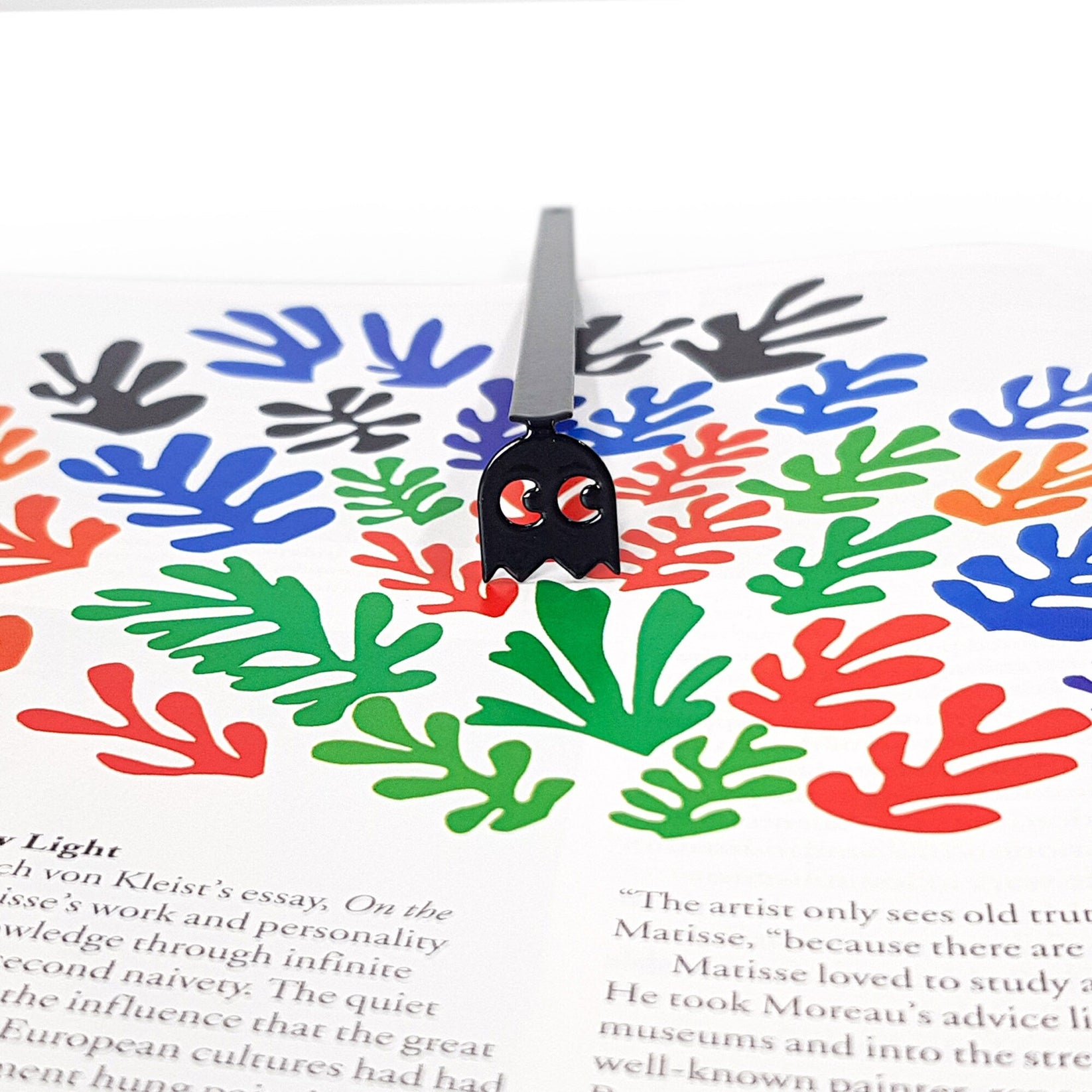Retro Ghost metal bookmark on an illustrated page