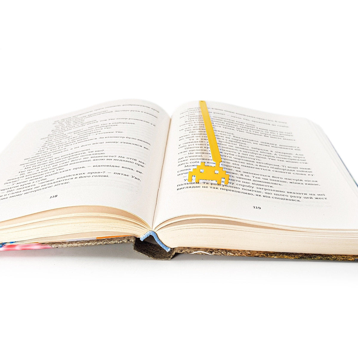 Retro Monster metal bookmark set into the gutter of an open book
