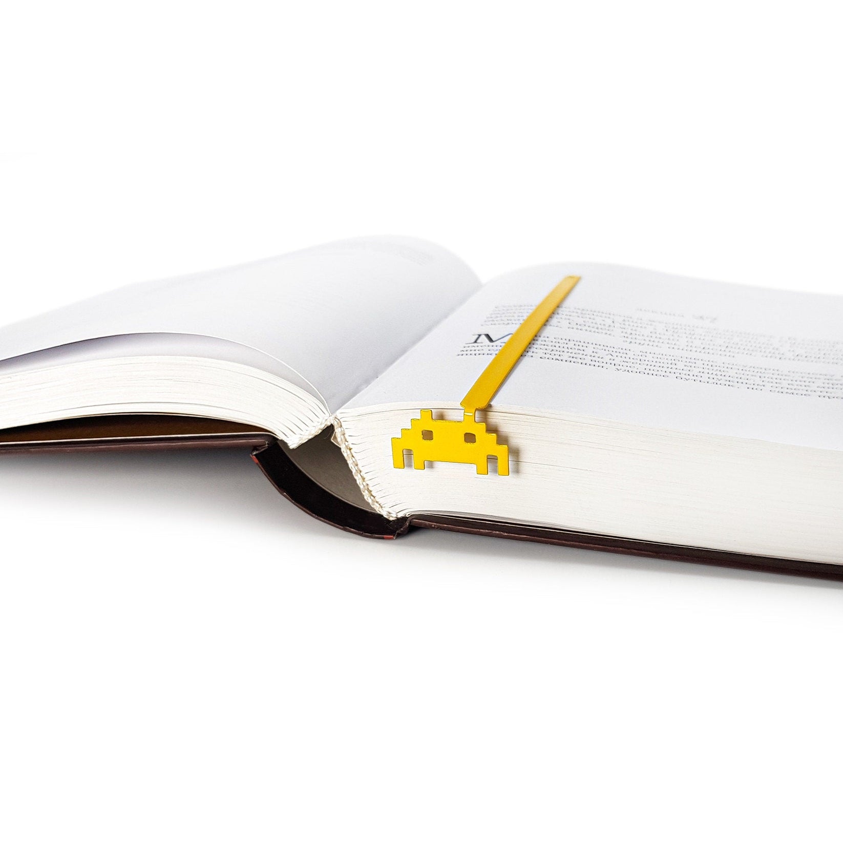 Retro Monster metal bookmark marking a page in an open book