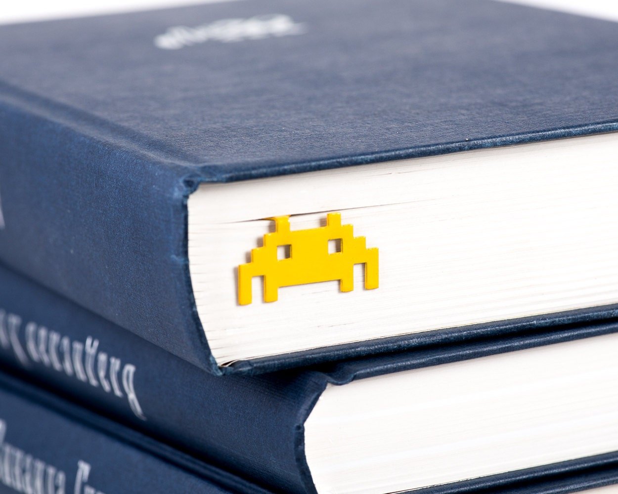 Retro Monster metal bookmark in a closed book, only its top showing above the pages