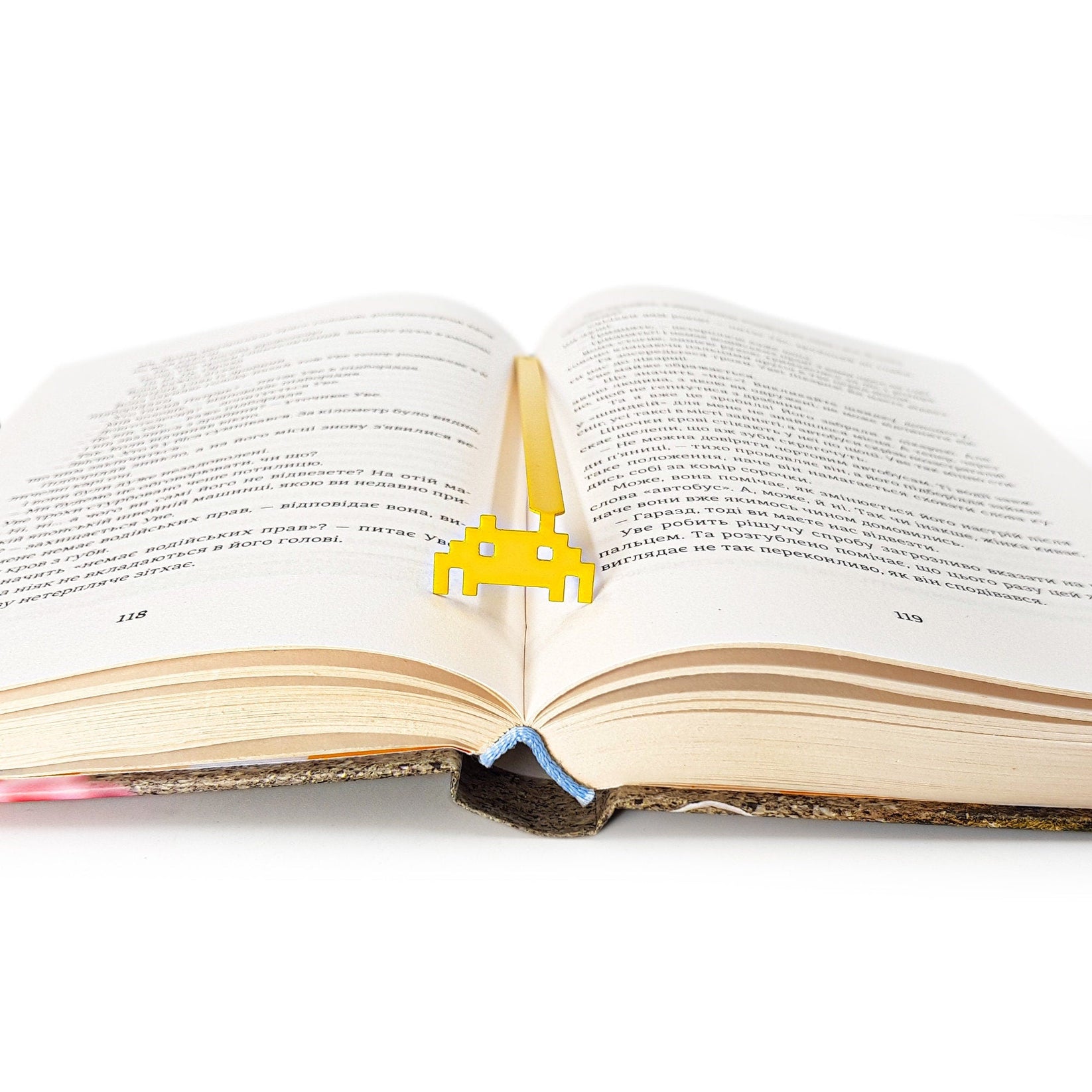 Retro Monster metal bookmark lying across the pages of an open book