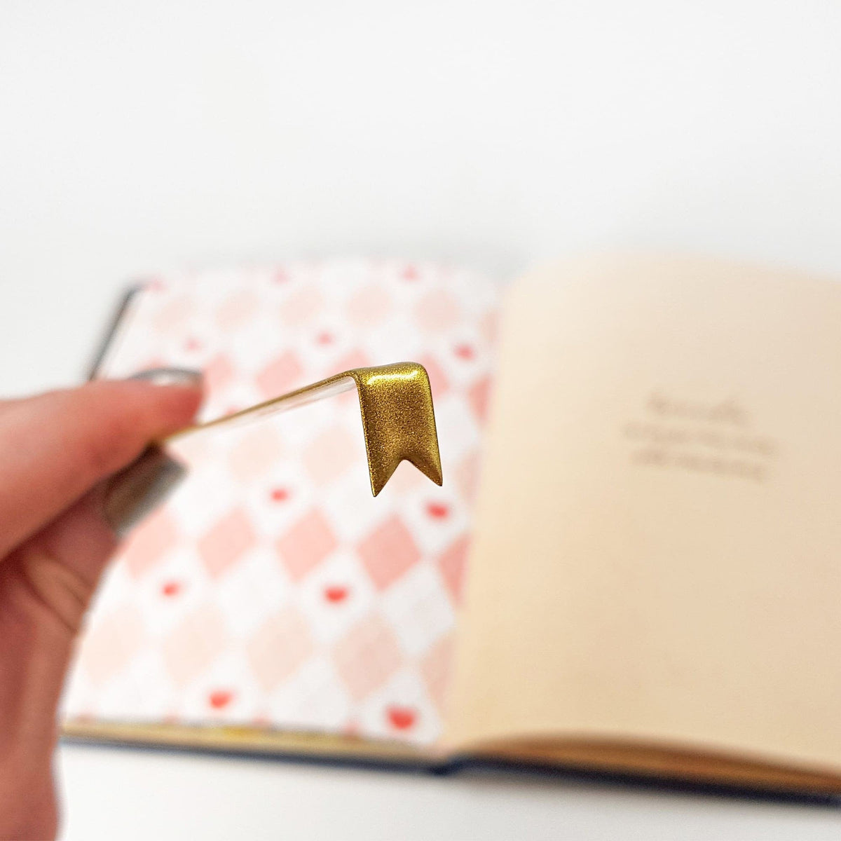 Ribbon metal bookmark in gold on a coloured background