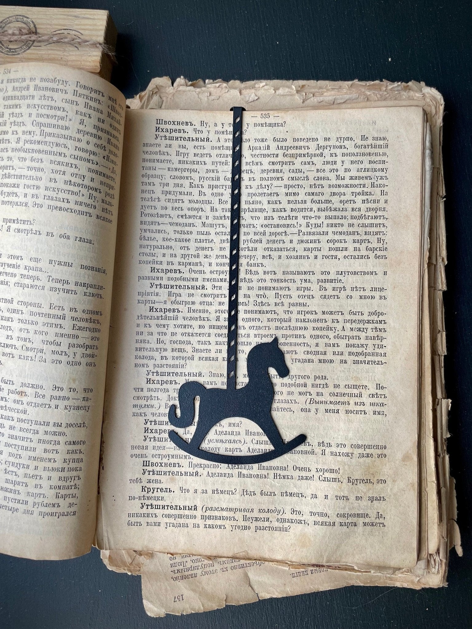 Rocking Horse metal bookmark resting on the pages of an open book