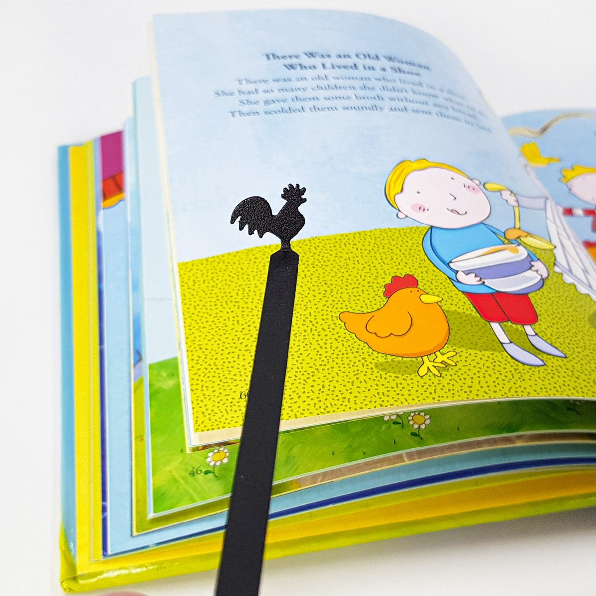 Rooster metal bookmark placed on a colour illustration
