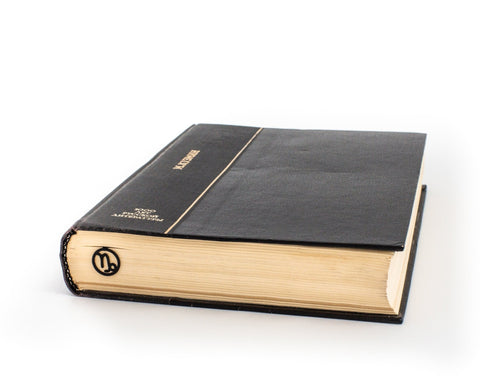 Capricorn metal bookmark in a closed book, only its top showing above the pages