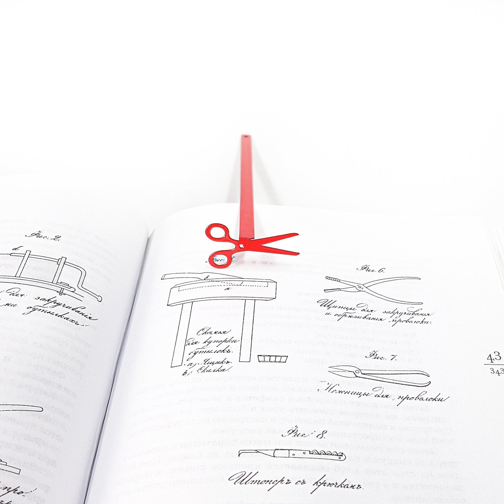 Scissors metal bookmark in red marking a page in a notebook, view 4