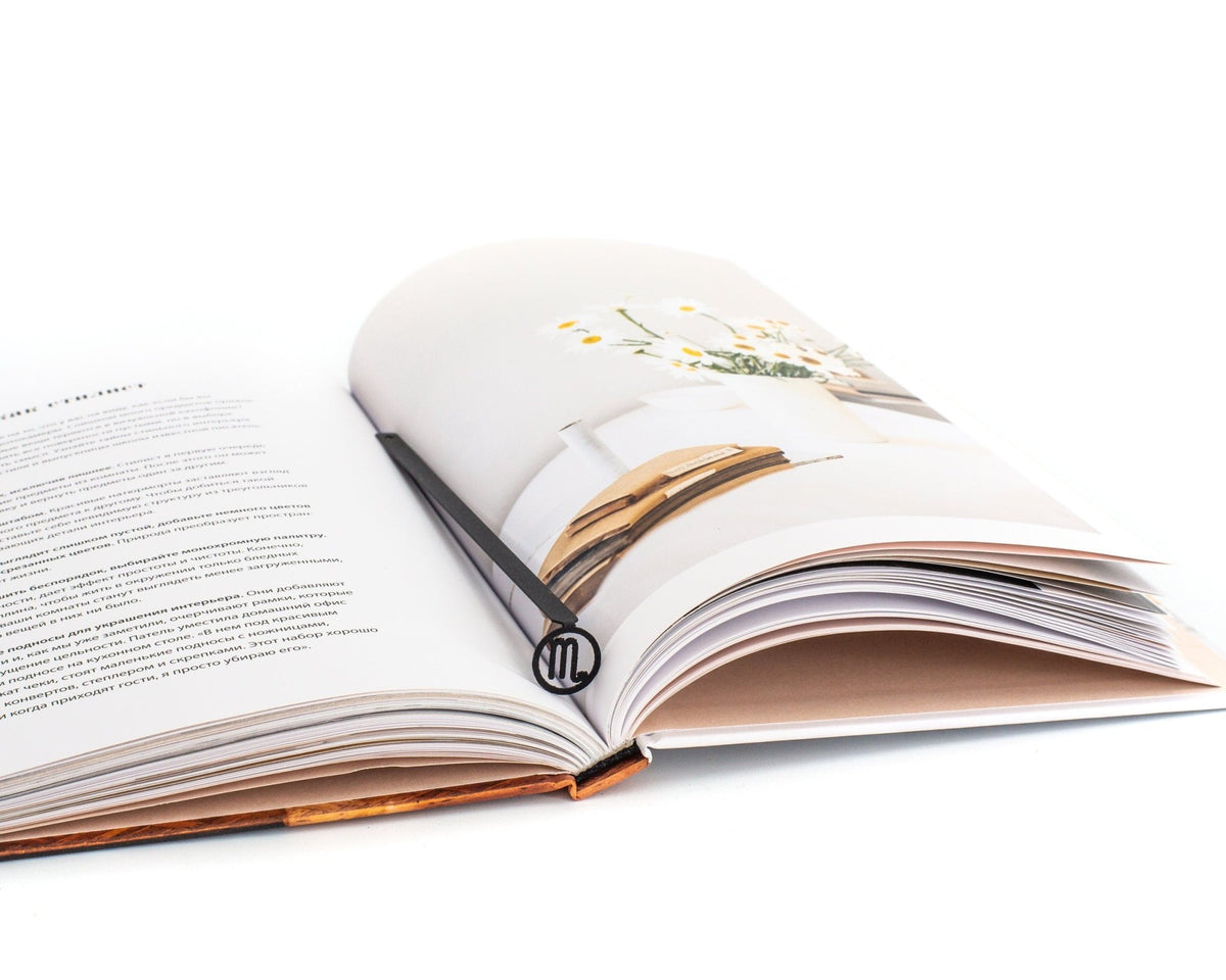 Scorpio metal bookmark resting on the pages of an open book