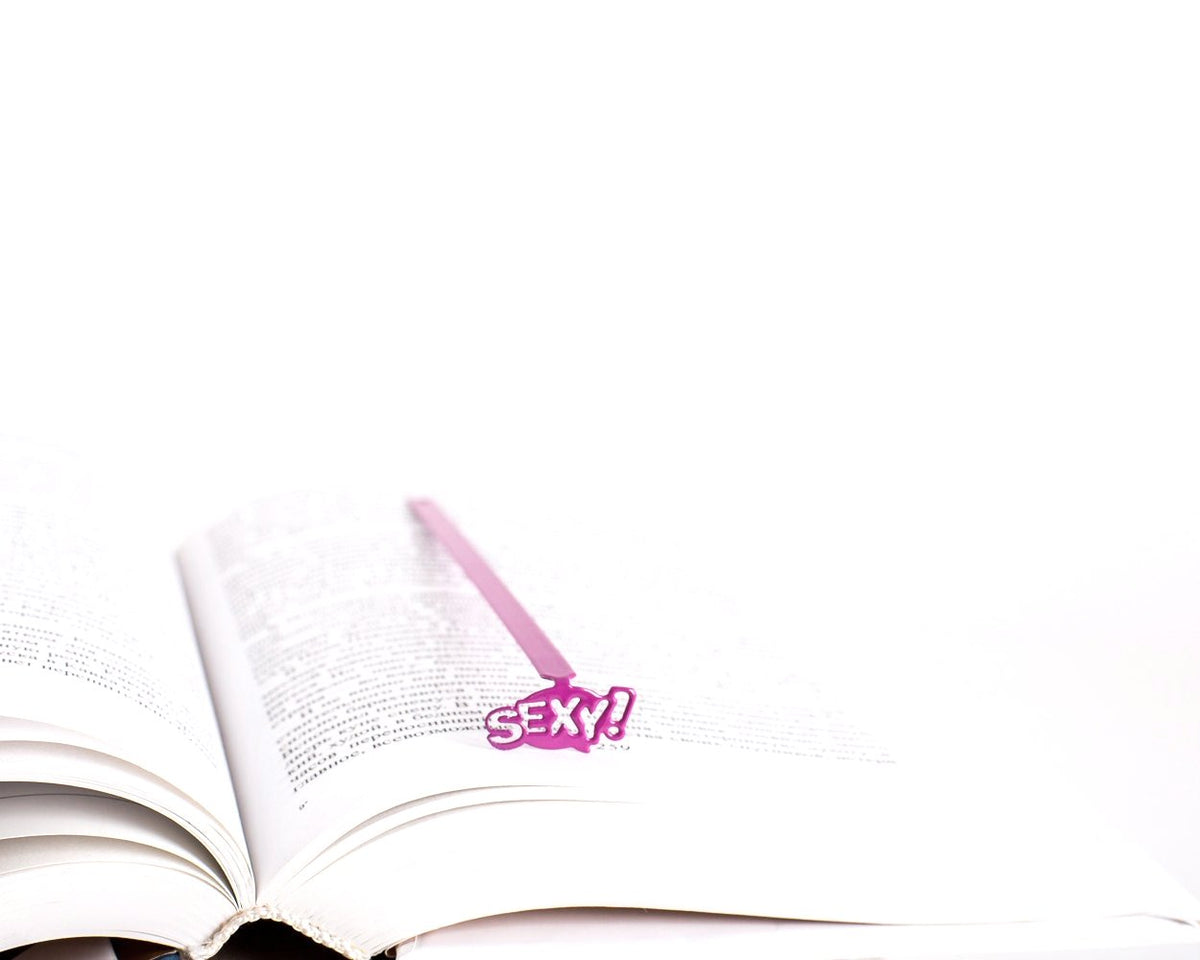 Sexy Smart metal bookmark resting on the pages of an open book