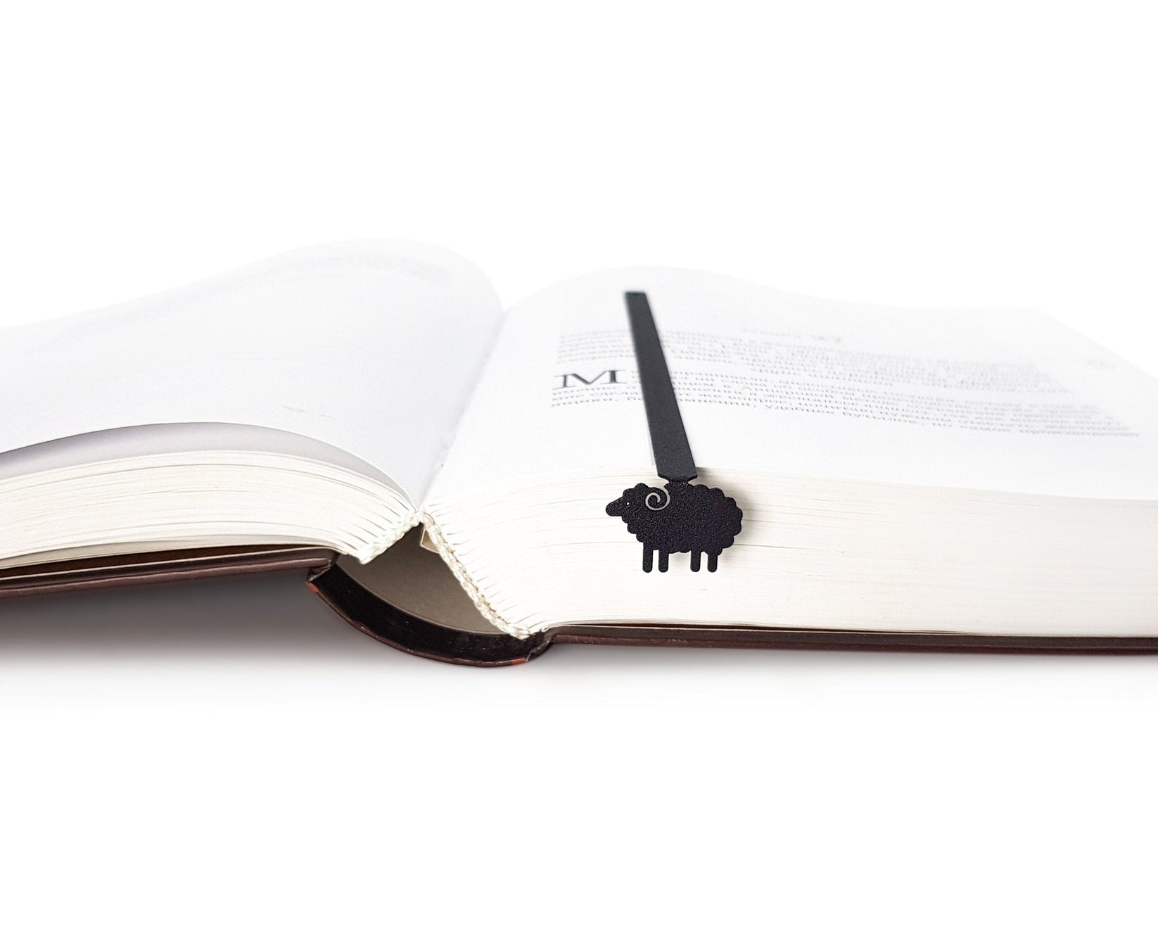 Sheep metal bookmark marking a page in an open book