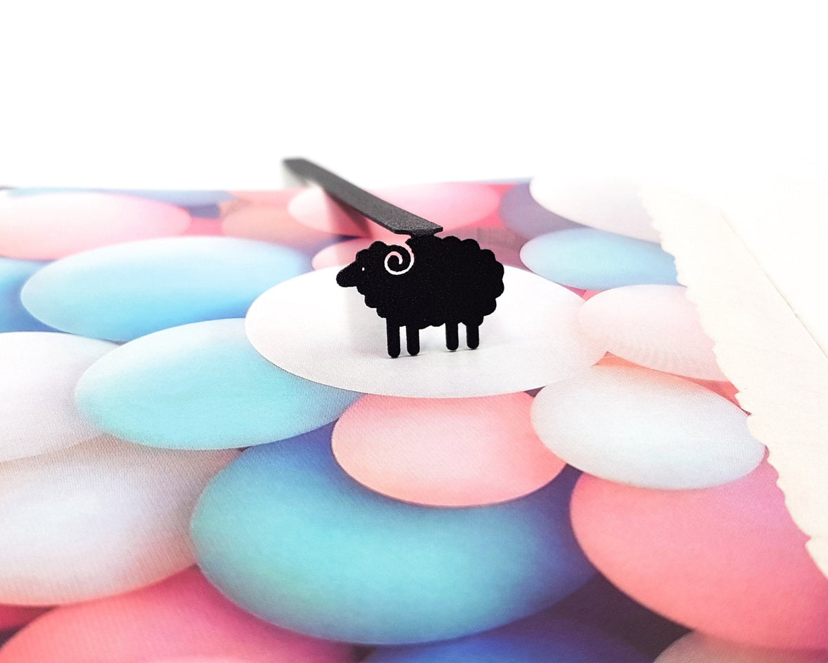 Sheep metal bookmark against a coloured backdrop