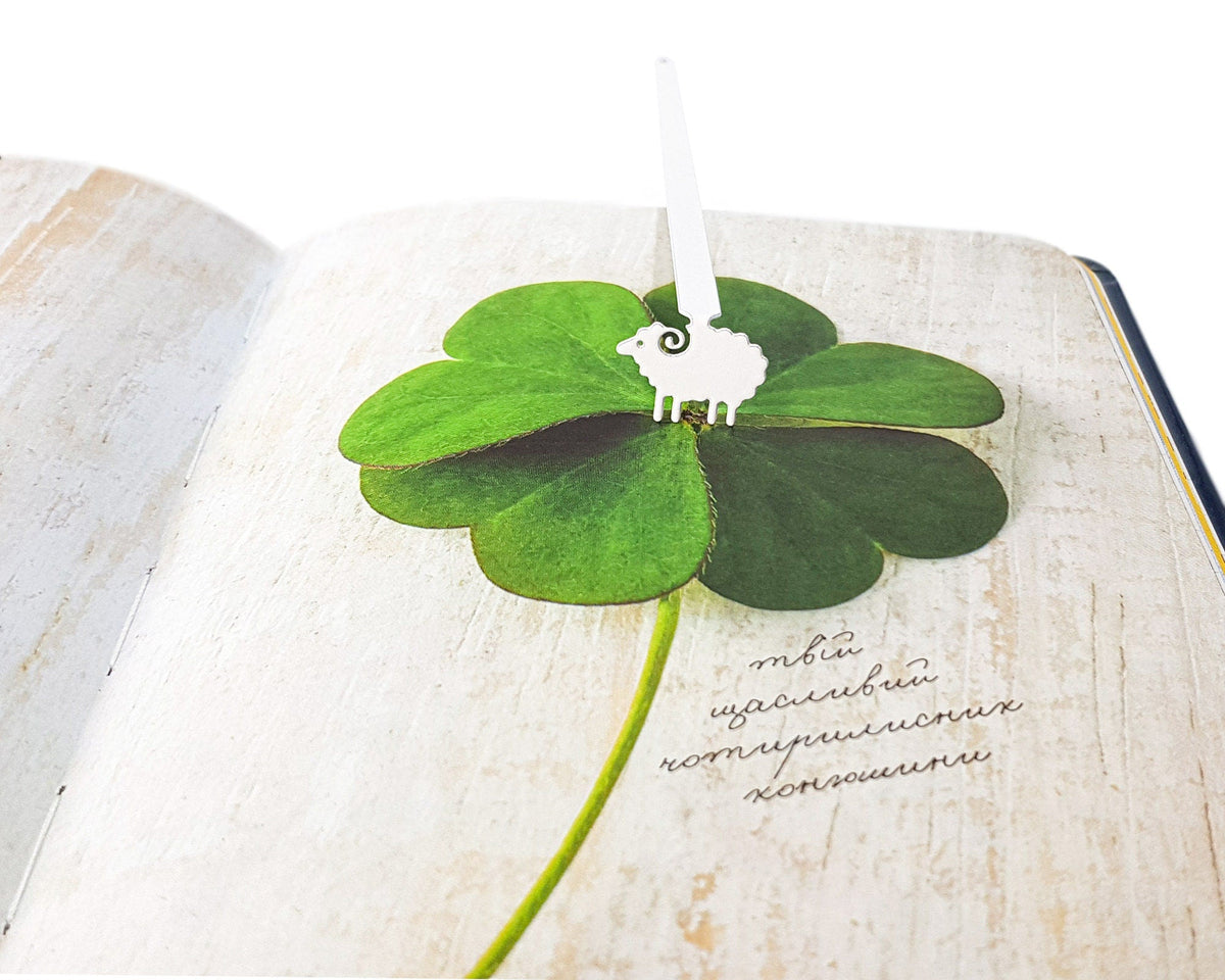 Sheep metal bookmark resting on the pages of an open book