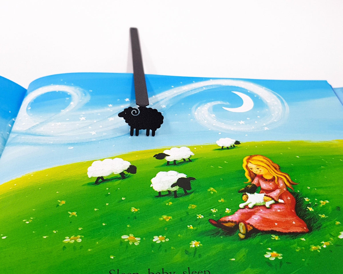 Sheep metal bookmark marking a page in an illustrated book