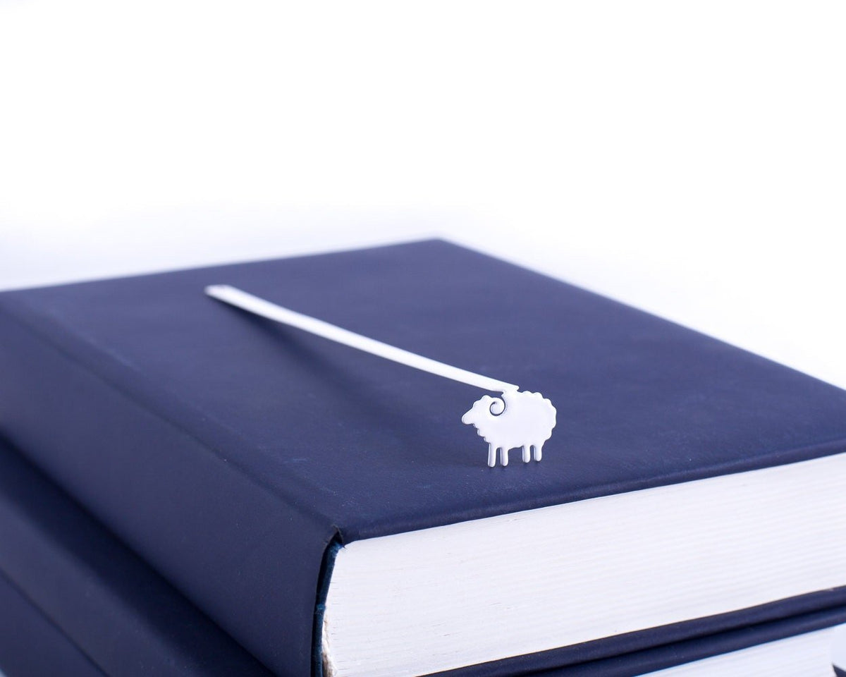 Sheep metal bookmark seen from the edge of a closed book