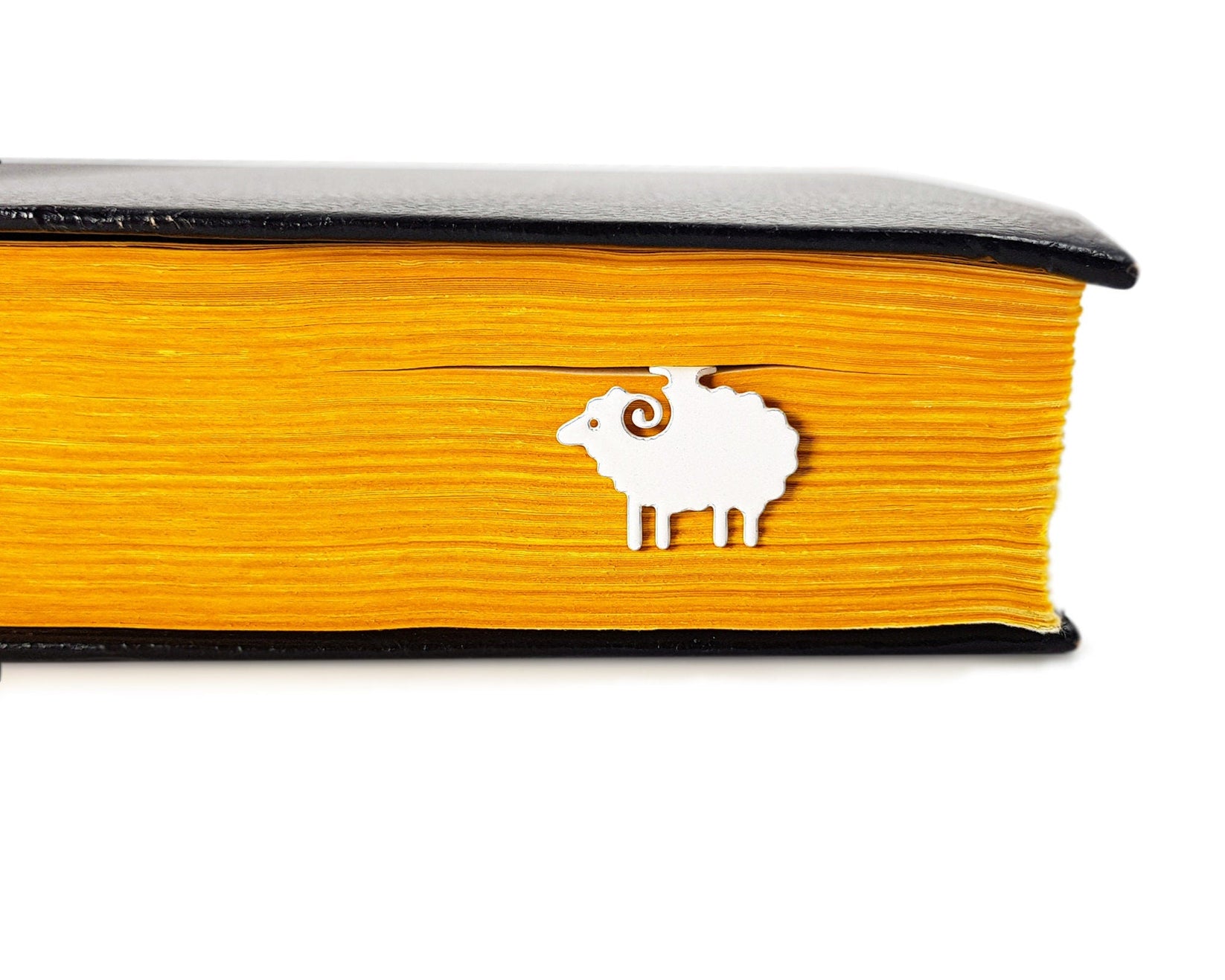 Sheep metal bookmark in a closed book, only its top showing above the pages