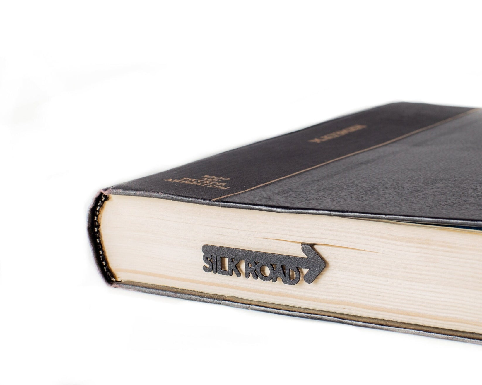 Silk Road metal bookmark clipped in a closed book, viewed from the side