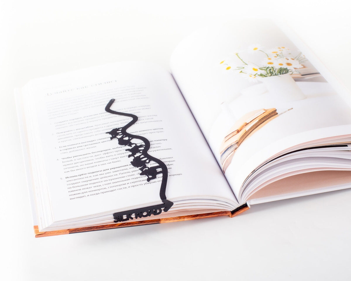Silk Road metal bookmark resting on the pages of an open book