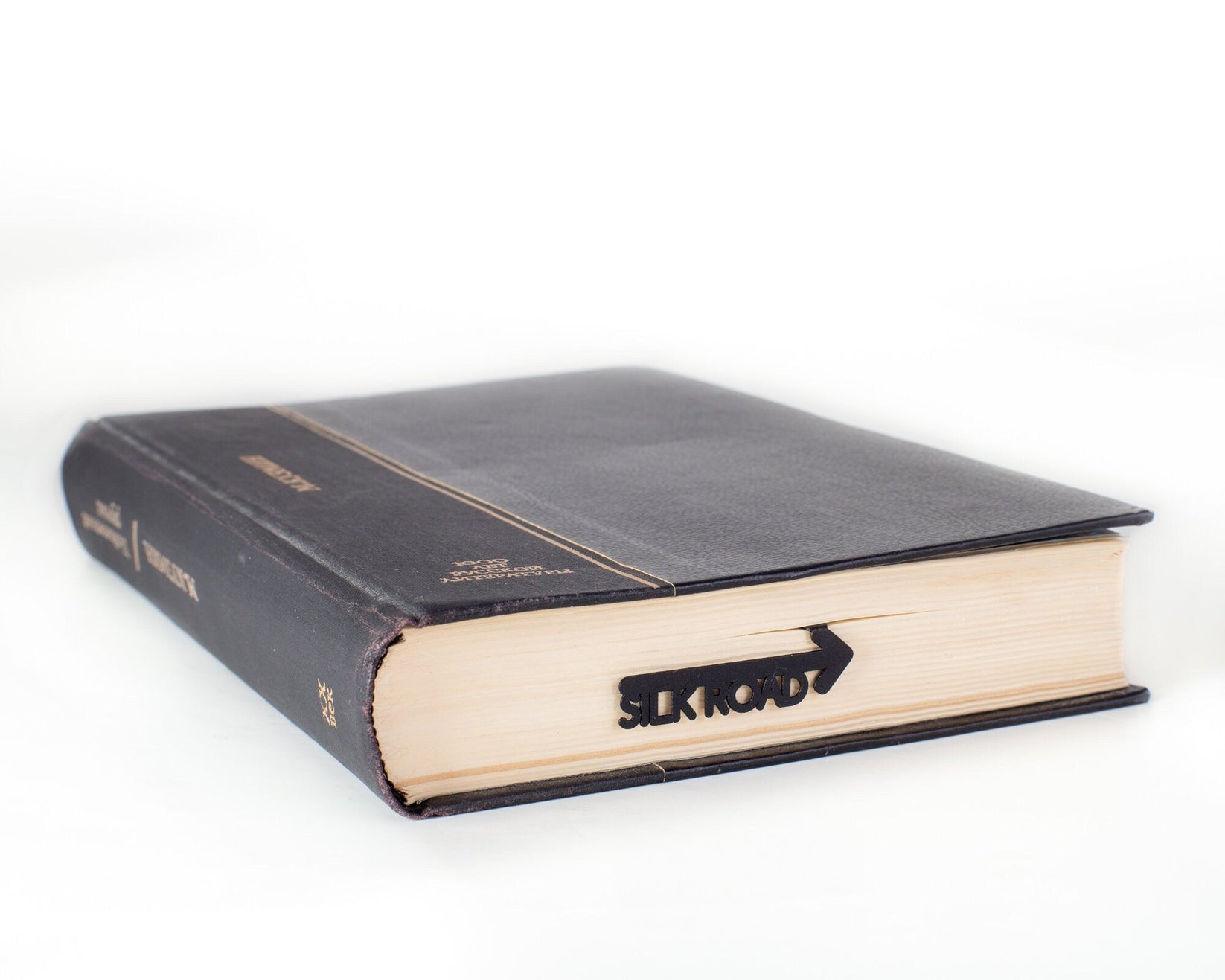 Silk Road metal bookmark seen from the edge of a closed book
