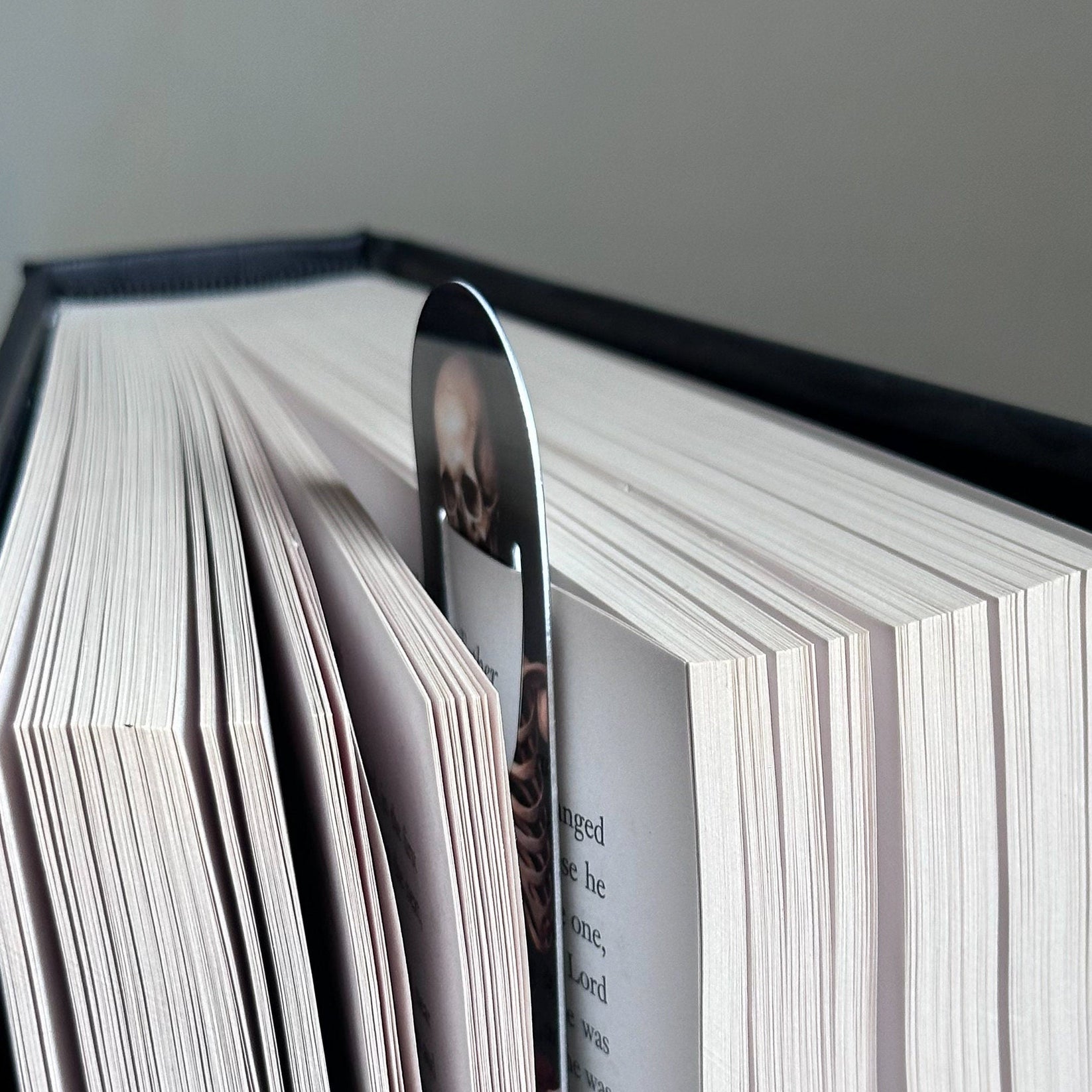 Skeleton with the Book metal bookmark resting on the pages of an open book