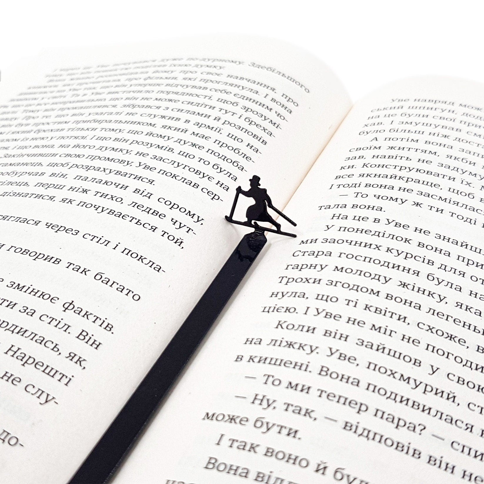 Skier in High Hat metal bookmark set into the gutter of an open book