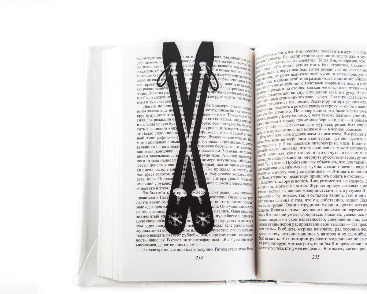 Skis metal bookmark resting on the pages of an open book
