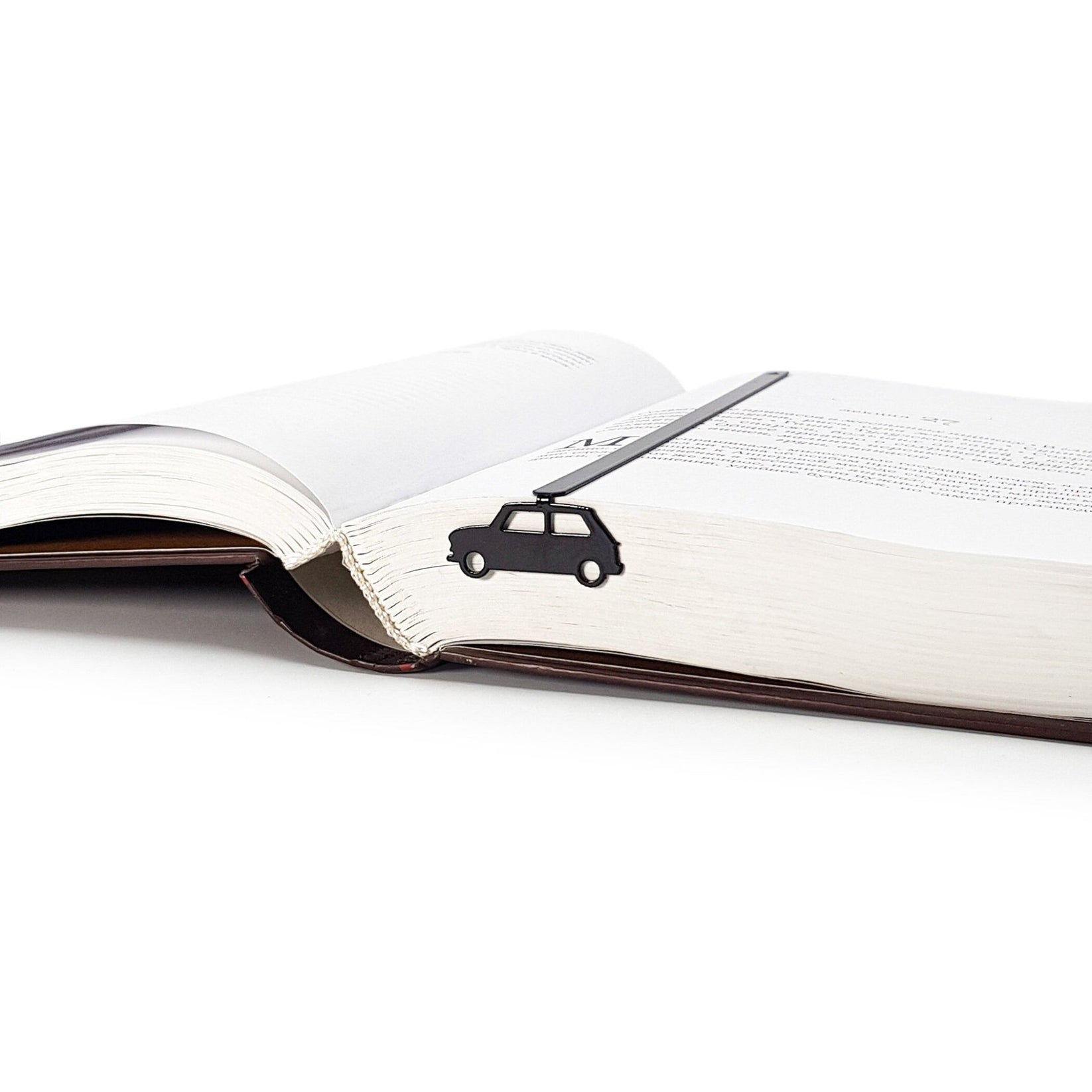 Black Car metal bookmark marking a page in an open book