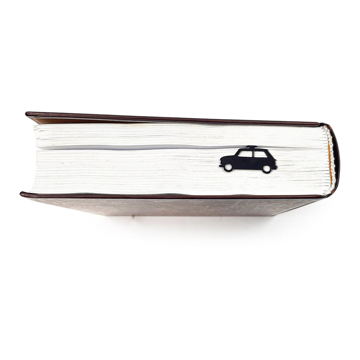 Black Car metal bookmark in a closed book, only its top showing above the pages