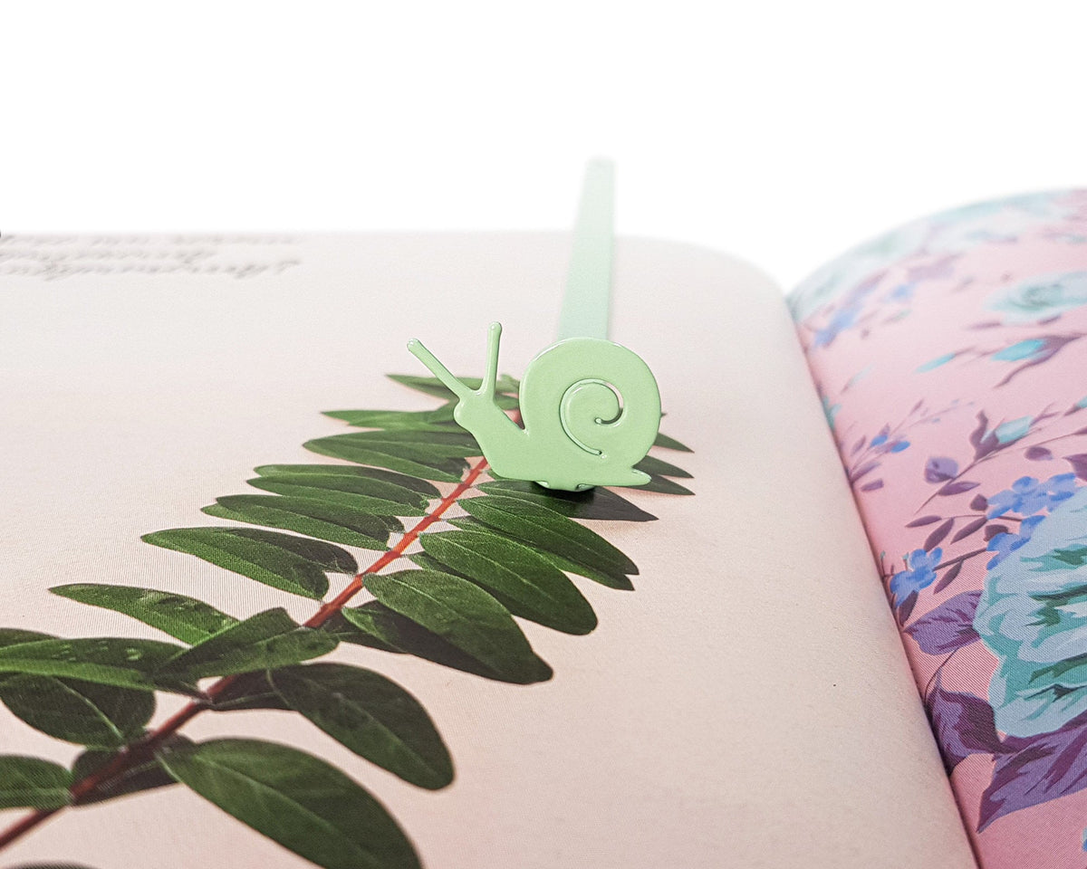 Snail metal bookmark in green against a coloured backdrop
