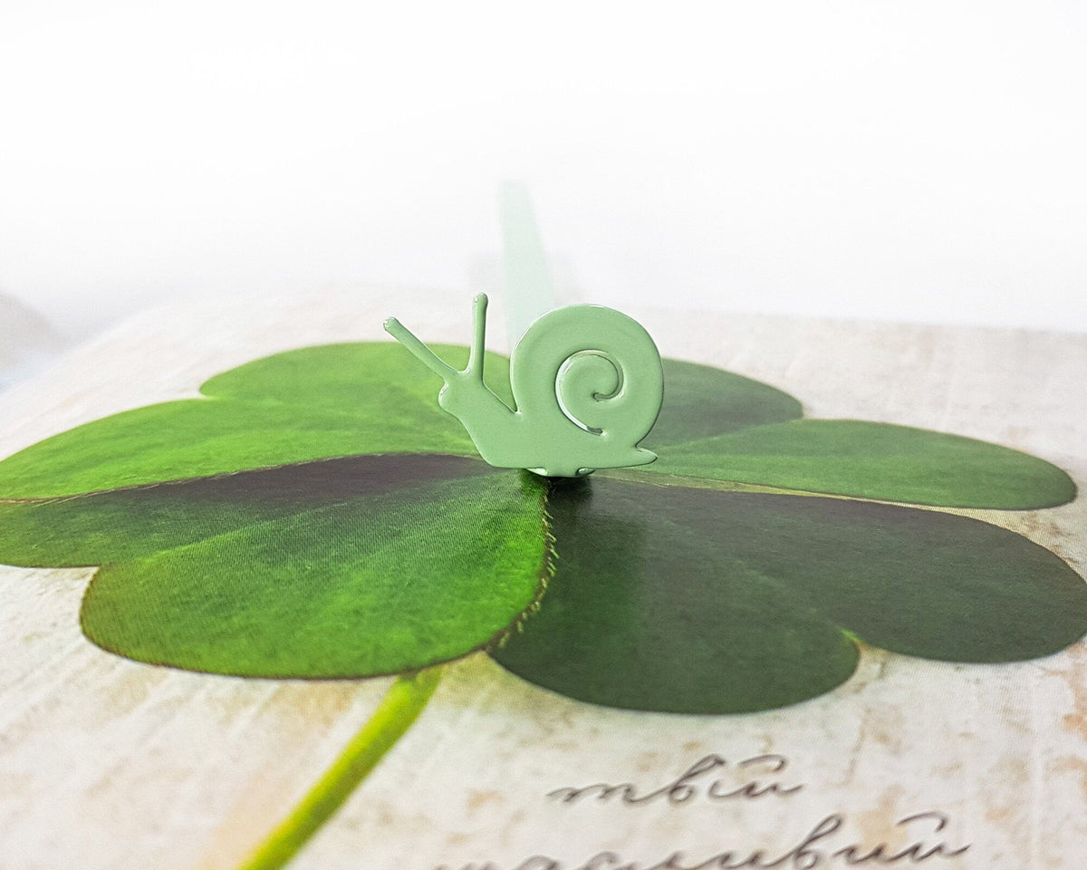 Snail metal bookmark in green on a coloured background
