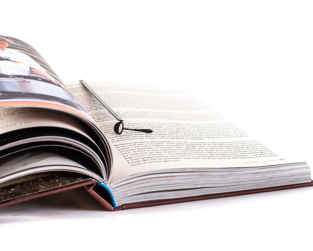 Soup Ladle metal bookmark lying across the pages of an open book