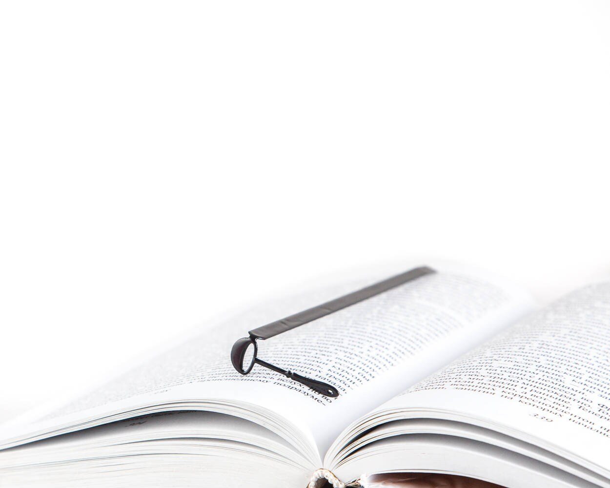 Soup Ladle metal bookmark resting on the pages of an open book