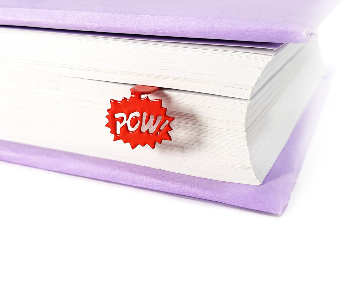 Speech Bubble Pow metal bookmark in red marking a place in a closed book